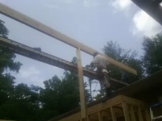 Carpenter setting a ridge beam over a new addition frame — Ice Dam Removal by Roofing Brothers in Pegram