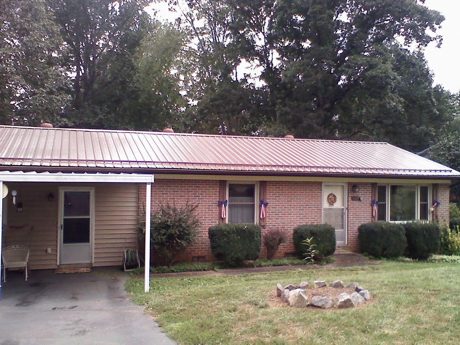 Bronze metal roof and carport on a brick ranch home — Roof Repair work by our crew in Pegram