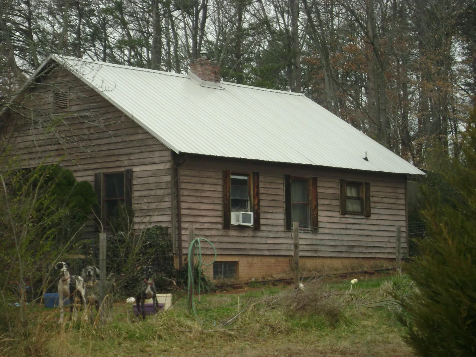 White metal roof on an old wood sided farmhouse, from a Metal Roof Installation job in Pegram